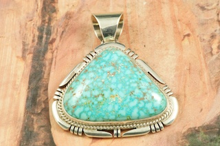 Genuine High Grade Kingman Web Turquoise set in Sterling Silver Pendant. Created by Navajo Artist Freddy Charley. Signed by the artist. The Mineral Park Mine, in the Cerbat Mountains 14 miles northwest of Kingman, was first mined by Indians centuries before white man came to the area. It is one of the three sites of prehistoric mining localities in the state of Arizona. Mineral Park was the most extensively worked area by the Indians of the three. S.A. �Chuck� Colbaugh found a cache of stone hammers uncovered in ancient trenches and tunnels, when he had the turquoise mining concession in May of 1962. Ithaca Peak and Turquoise Mine (formally called Aztec Mountain or Aztec Peak) are the most famous of the peaks in the area containing turquoise. Free 18